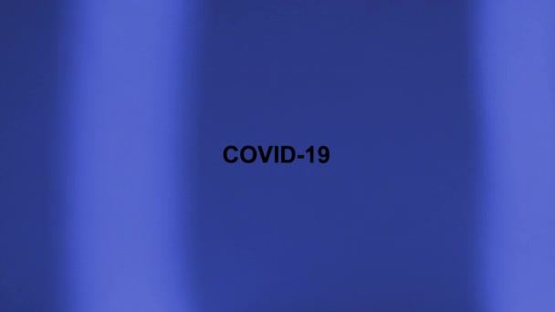 Iscrizione nera COVID-19 su sfondo blu. Le strisce luminose si muovono da un lato all'altro . — Video Stock