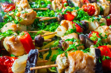 Tavuk, patlıcan, domates, tatlı biber ve mantar dilimleri ahşap şişler üzerine dizilir ve kızarana kadar kızartılır. Taze doğranmış kişniş, maydanoz ve taze soğanla nefis bir lezzet..