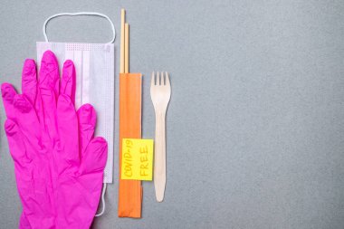 Çatal, yemek çubuğu, tıbbi maske, pembe lateks eldivenler ve üzerinde 