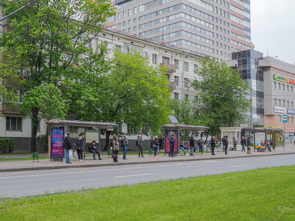 Москва, Россия. 14 мая 2020 года. Пассажиры в медицинских масках на остановке общественного транспорта ждут прибытия автобуса. Ограничительные меры во время карантина эпидемии коронавируса
.