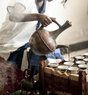 Woman hand pouring coffee for traditional Ethiopian coffee ceremony clipart