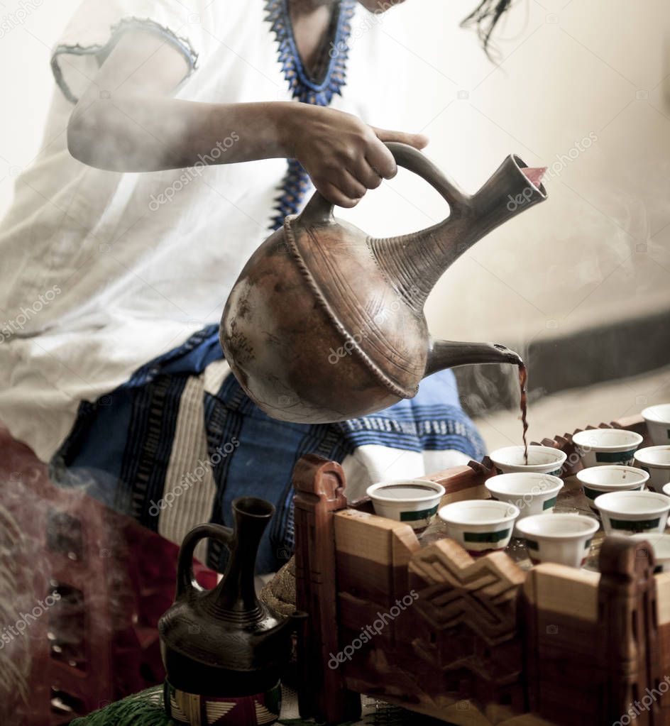 Woman hand pouring coffee for traditional Ethiopian coffee ceremony