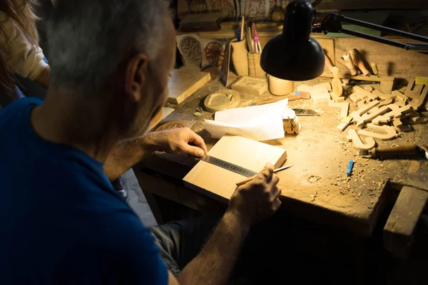 Mann arbeitet mit Baum und schnitzt Souvenirs — Stockfoto