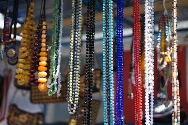 beads from different stones hang on a stand