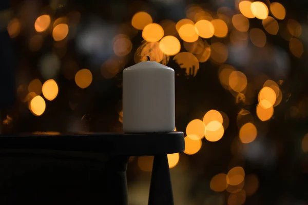 Vela de cera no fundo de uma árvore de Natal com luzes — Fotografia de Stock