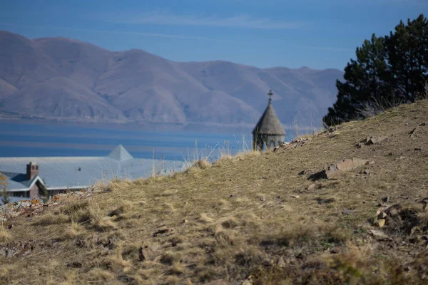 A lake with rocks and a church peeps out — Stok fotoğraf