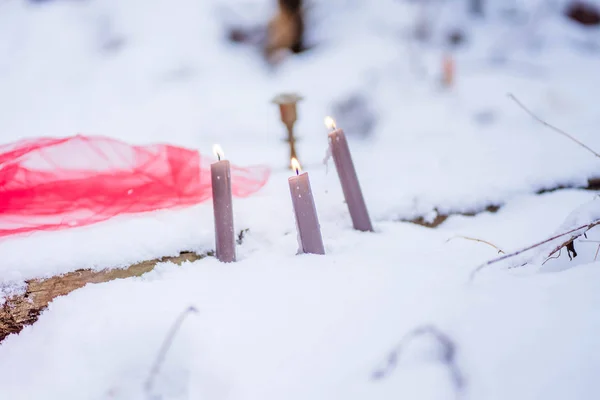 Burning candles stand in the snow — 스톡 사진