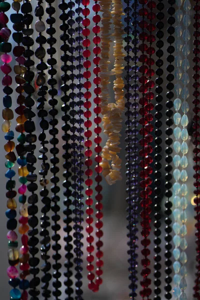 Beads hang from multi-colored pebbles — 스톡 사진