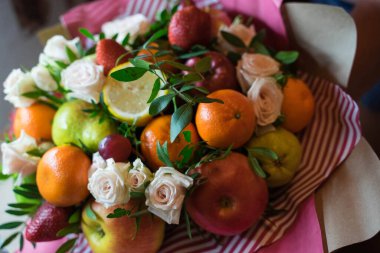 fruit and berry bouquet with roses in a package
