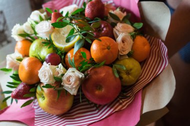 fruit and berry bouquet with roses in a package