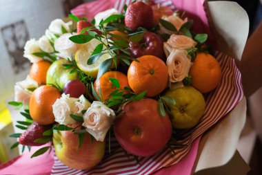 fruit and berry bouquet with roses in a package