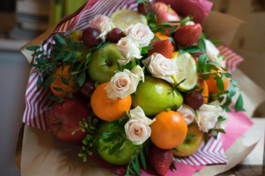 fruit and berry bouquet with roses in a package