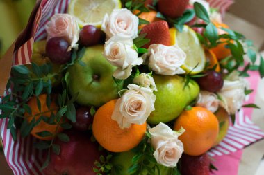 fruit and berry bouquet with roses in a package