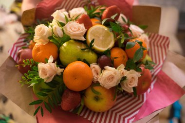 fruit and berry bouquet with roses in a package
