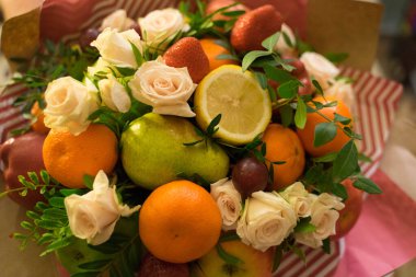 fruit and berry bouquet with roses in a package