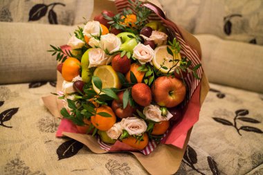 fruit and berry bouquet with roses in a package
