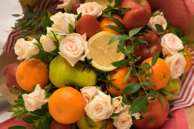 fruit and berry bouquet with roses in a package