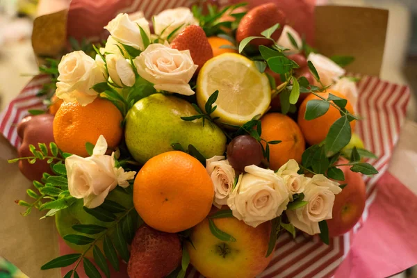 fruit and berry bouquet with roses in a package