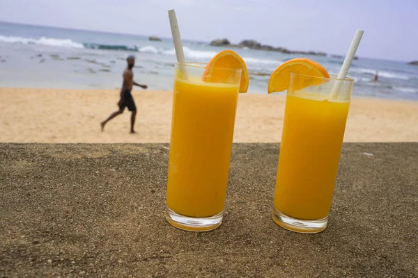 Suco de laranja em copos transparentes e um milkshake — Fotografia de Stock