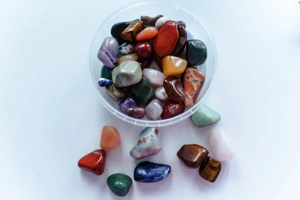 Flerfärgade stenar av olika storlekar på en vit bakgrund — Stockfoto