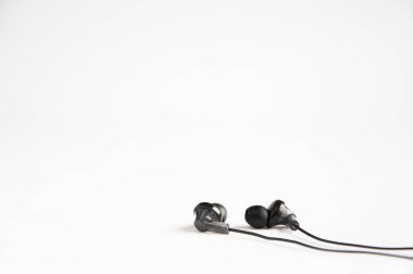 Masanın üzerinde siyah süpürge kulaklıkları var. Beyaz arkaplanda.