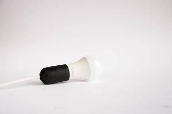Біла Економічна Лампочка Чорному Картриджі Лежить Столі Білому Тлі — стокове фото