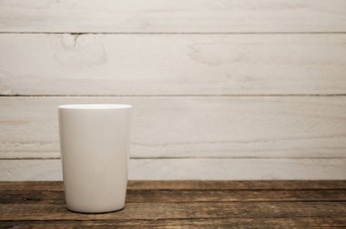 Beyaz bardaklar ahşap bir masanın üzerinde duruyor. Ahşap doku.