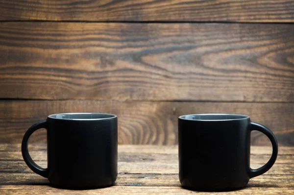 木製のテーブルの上に黒いカップが立っている 朝のお茶とコーヒー — ストック写真
