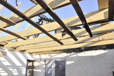 Yangından sonra bir ev inşa etmek. Yeni ahşap kirişler. Kömürleşmiş tahtalar