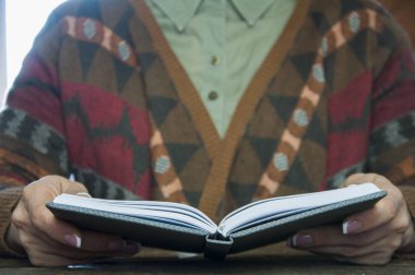 Bir kadının elinde açık bir defter ya da defter..