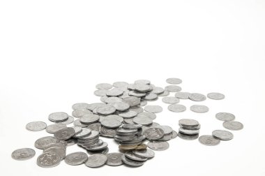 Bir sürü bozuk para saçılmış. Zenginlik ve bolluk kavramı. Beyaz arkaplanda