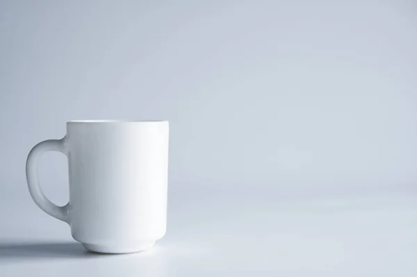テーブルの上に白い磁器のカップが立っている 白地に — ストック写真