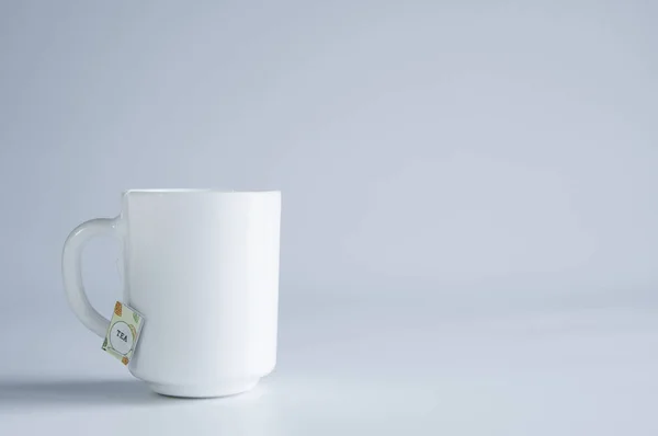 一只白色瓷杯立在桌子上 白色背景 — 图库照片