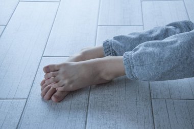 Gri pantolonlu küçük bir çocuğun bacakları. Yakın plan.