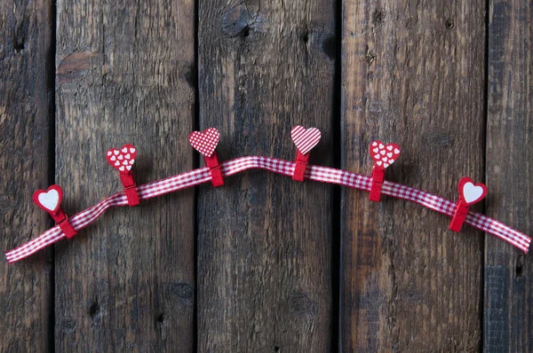Küçük Kırmızı Çengelli Kalpler Ahşap Bir Arka Planda Bir Kumaş — Stok fotoğraf