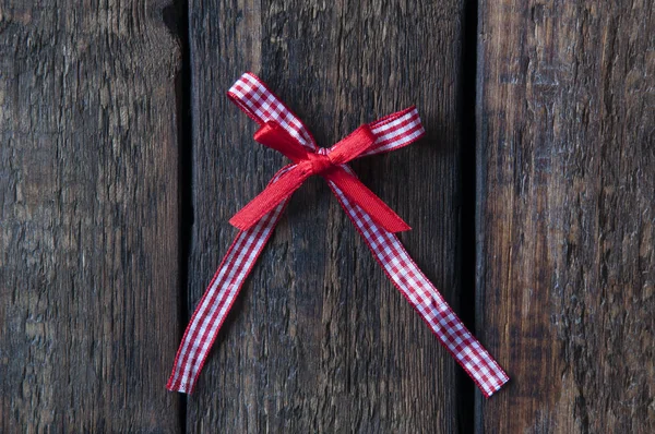 Red bow on a wooden background. Jewelry