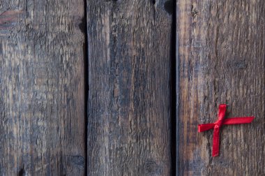 Ahşap arka planda küçük kırmızı bir fiyonk. Aşk