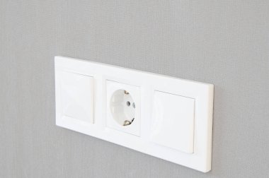 Beyaz plastik euro soketi. Gri duvarda