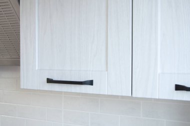 Mutfak dolabının beyaz kapısı. Siyah tutucu