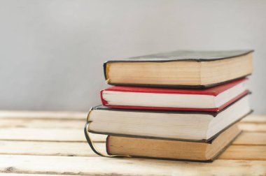 Tahta bir masanın üzerinde bir yığın kitap..