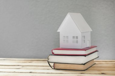 Kağıt ev. Masada bir yığın kitap var..