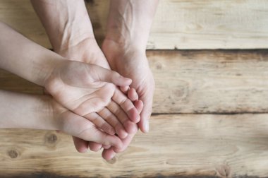 Bir kadının ellerinde bir çocuğun elleri var. Anne 'nin çocuğa olan sevgisi.