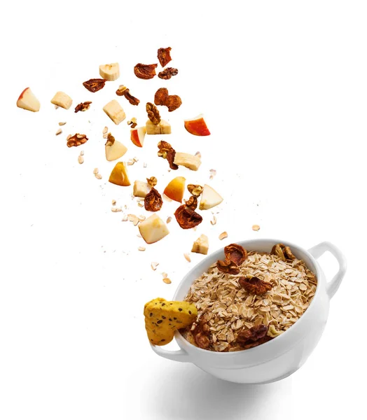 Bowl of healthy oatmeal with falling fruit with the ingredients in the air — Stock Photo, Image