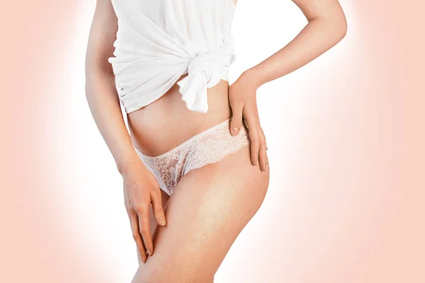 Jovem mulher sexy em calças brancas e camisa tocando seu quadril — Fotografia de Stock