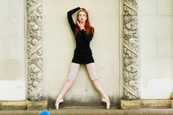 Balletdanser. Mooie sierlijke ballerine in zwarte praktijk ballet plie posities in de buurt van de grote muur, kopie ruimte — Stockfoto