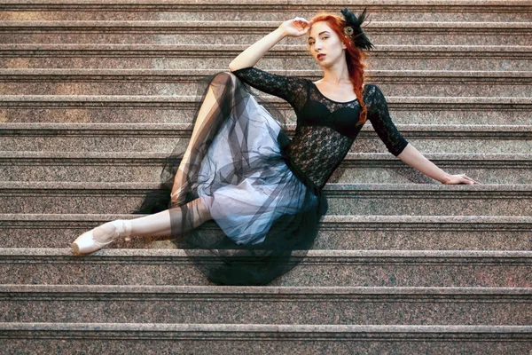 Ballerina buitenshuis, poses zittend op de trap — Stockfoto