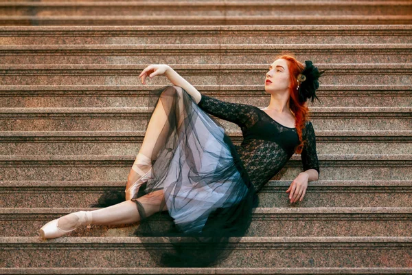 Ballerina buitenshuis, poses zittend op de trap — Stockfoto