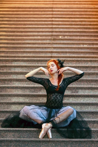 Ballerina buitenshuis, poses zittend op de trap — Stockfoto