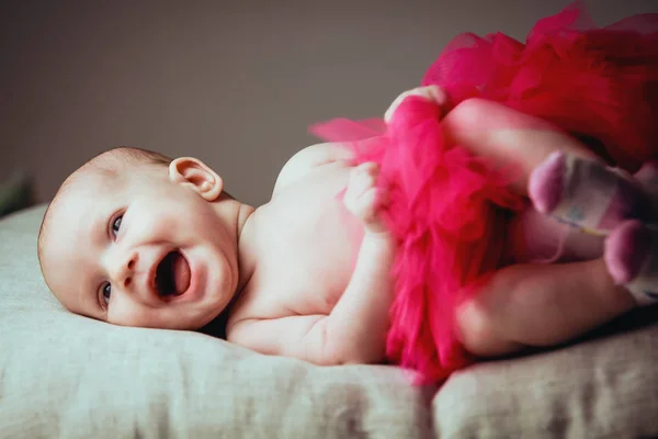 Retrato um risos muito em voz alta bonito pequeno 1-2 mês de idade bebê no travesseiro na saia bailarina — Fotografia de Stock