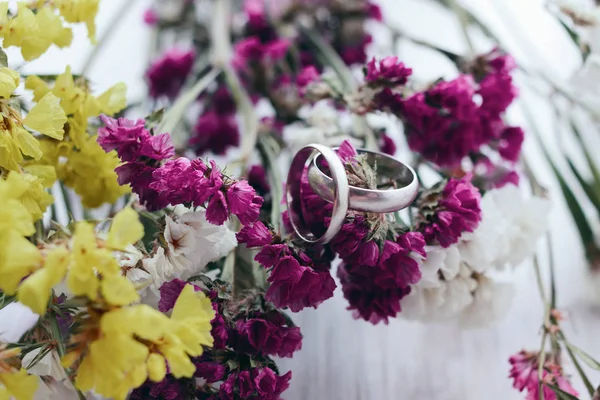 Vigselringar på en blommor bukett. Accessoarer bröllop närbild. — Stockfoto